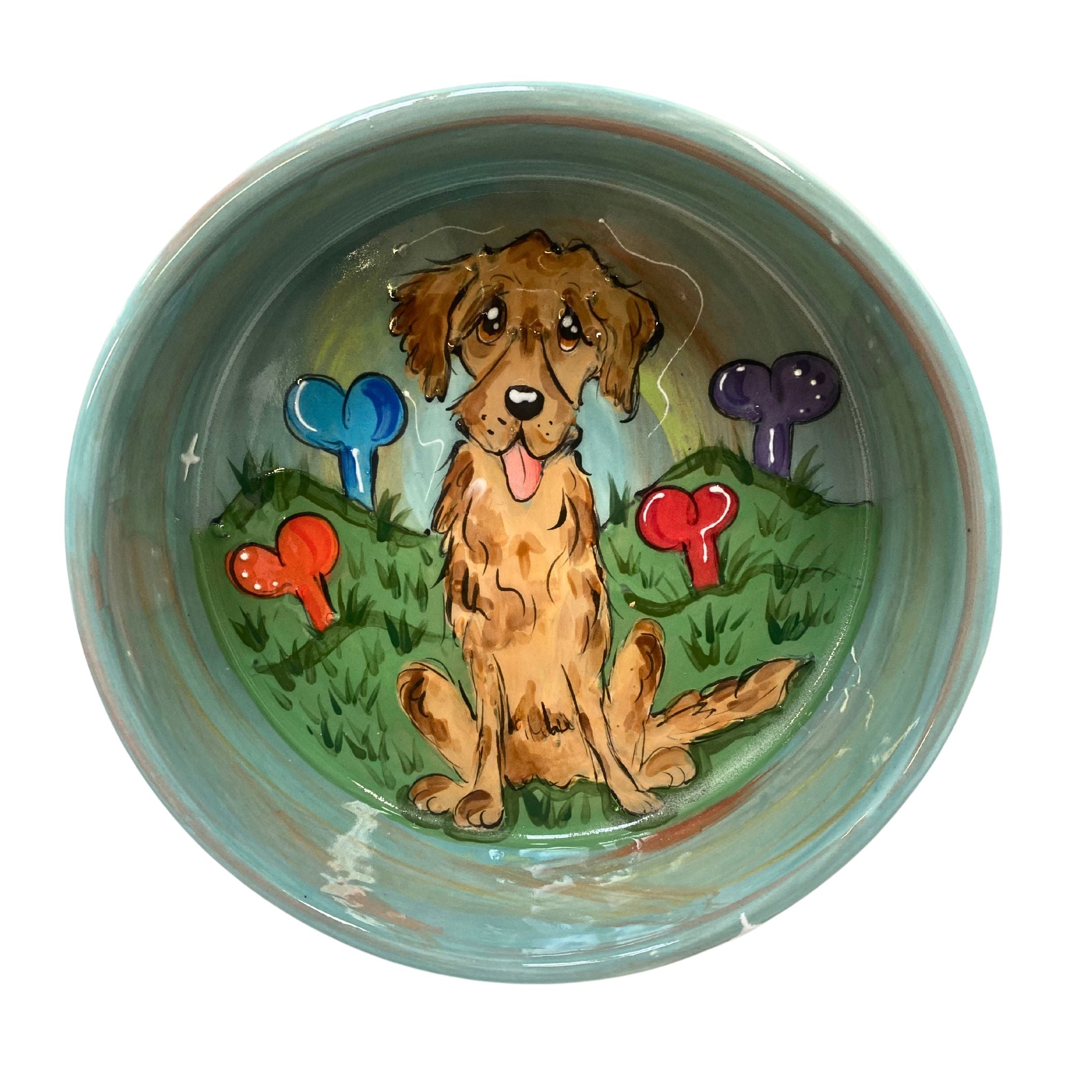 Hand-painted ceramic dog bowl with a depiction of a cute puppy surrounded by colorful, whimsical trees on a teal background, from FauxPaw&