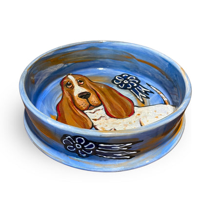 Side view of a basset hound award bowl, with a sky-blue interior and cloud motifs, representing the high standards of breed club show events