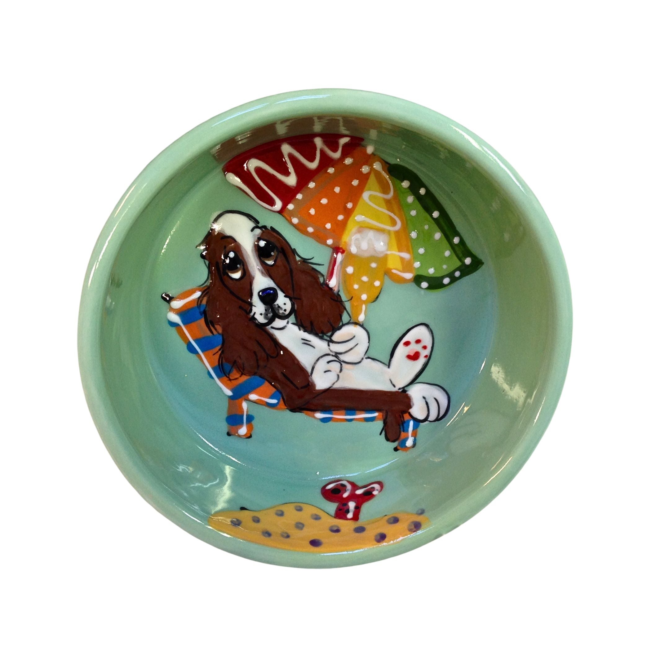 Custom King Charles dog ceramic pet bowl, hand-painted by artist Debby Carman, featuring vibrant beach-themed artwork.