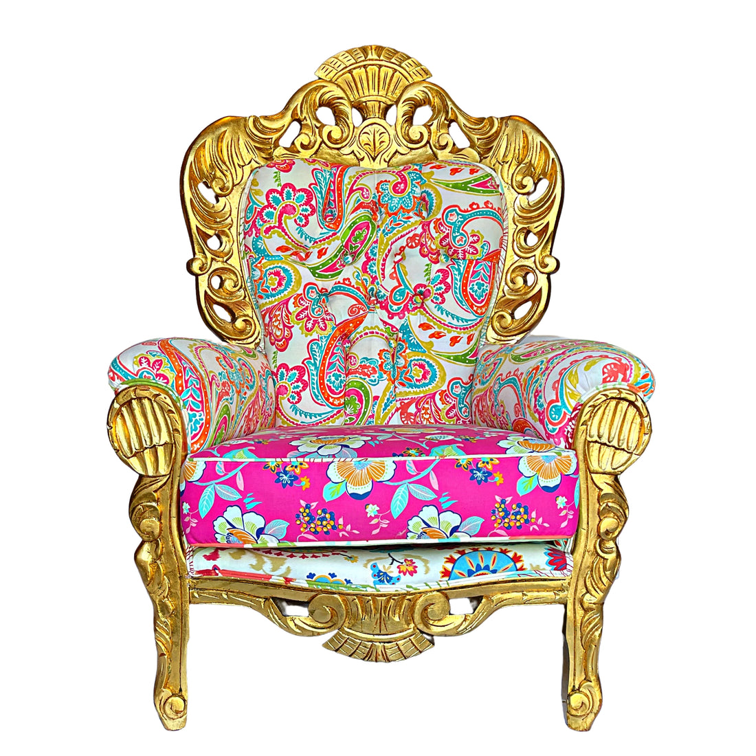 Frontal view of a luxurious baroque armchair with a glossy gold frame, adorned with elaborate carvings and upholstered in a bright paisley and floral pattern with pink, turquoise, and gold colors