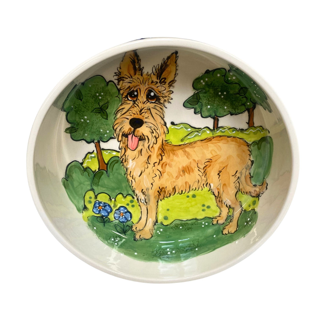 Hand-painted ceramic dog bowl featuring a joyful dog in a green meadow with blue flowers, part of the &quot;Whiskers &amp; Wilderness&quot; Collection on FauxPaw.com, capturing the serene essence of nature for your pet&