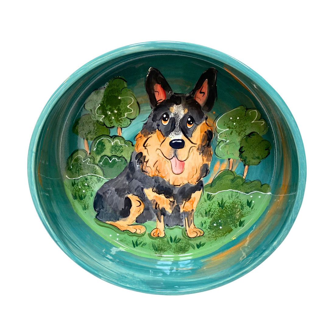 Handcrafted ceramic bowl with a detailed painting of a Blue Heeler dog in a park setting, showcasing vibrant colors and a glossy finish, available in our artisan petware collection.