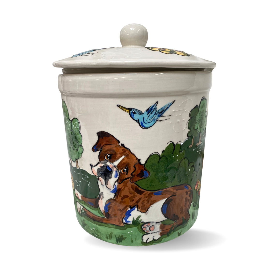 Hand-painted ceramic treat jar featuring a boxer dog and a blue bird in flight against a lush green backdrop, with a snug-fitting lid