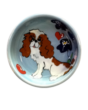 Sweet King Charles Blenheim sitting in flowers dog bowl