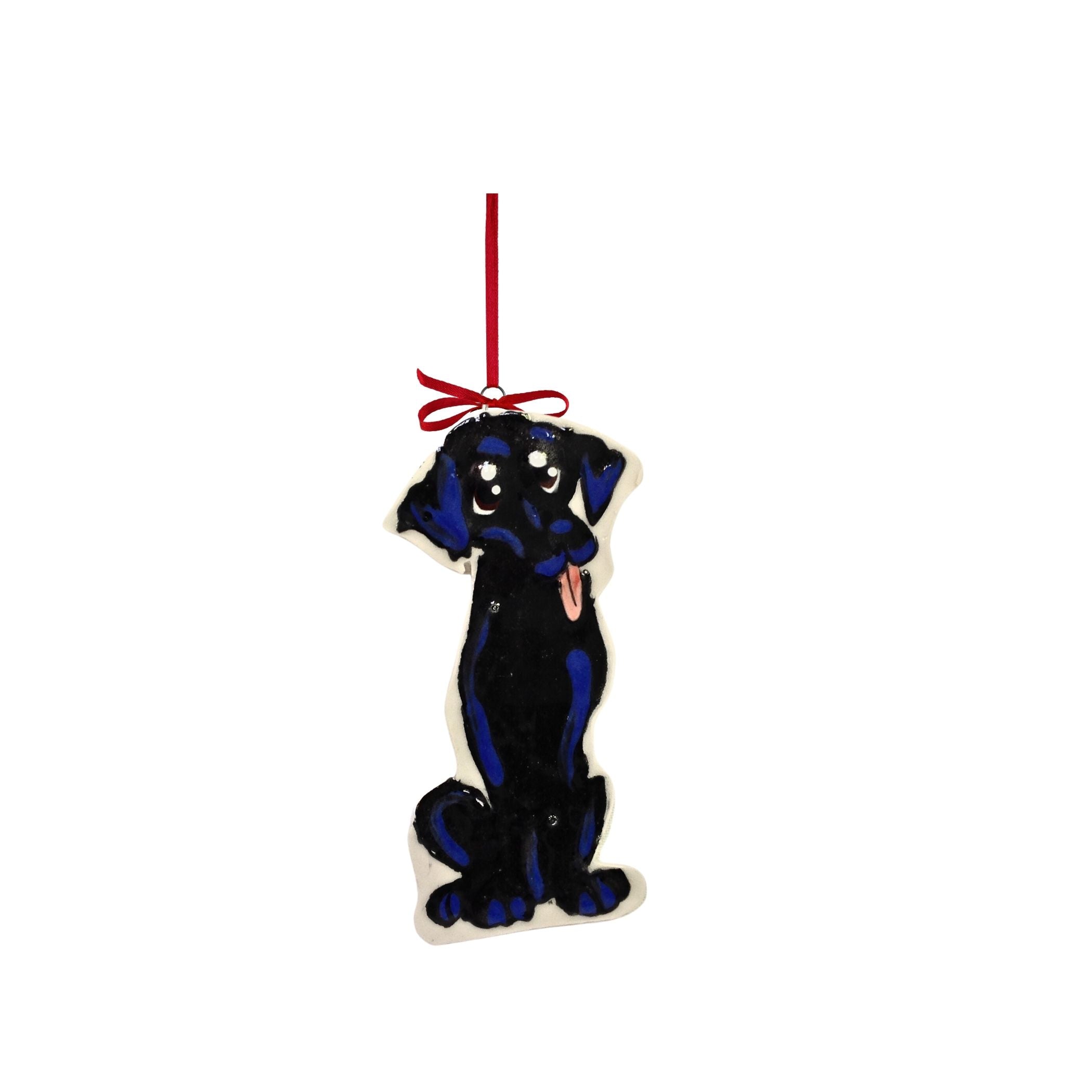 Ceramic ornament of a black labrador retriever with a playful tongue-out expression, standing on its hind legs, adorned with a red ribbon at the top