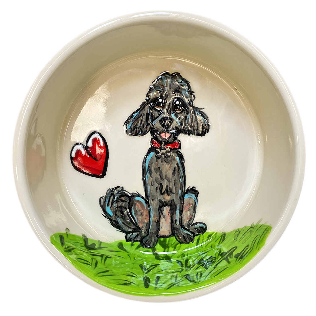 Delicate ceramic bowl with a cream interior, showcasing a hand-painted grey poodle sitting on a lush green grass patch. Beside the poodle is a glossy red heart, symbolizing love and companionship. The poodle, with a red collar, gazes upward with affectionate eyes, inviting a loving atmosphere into any space.