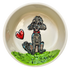 Delicate ceramic bowl with a cream interior, showcasing a hand-painted grey poodle sitting on a lush green grass patch. Beside the poodle is a glossy red heart, symbolizing love and companionship. The poodle, with a red collar, gazes upward with affectionate eyes, inviting a loving atmosphere into any space.