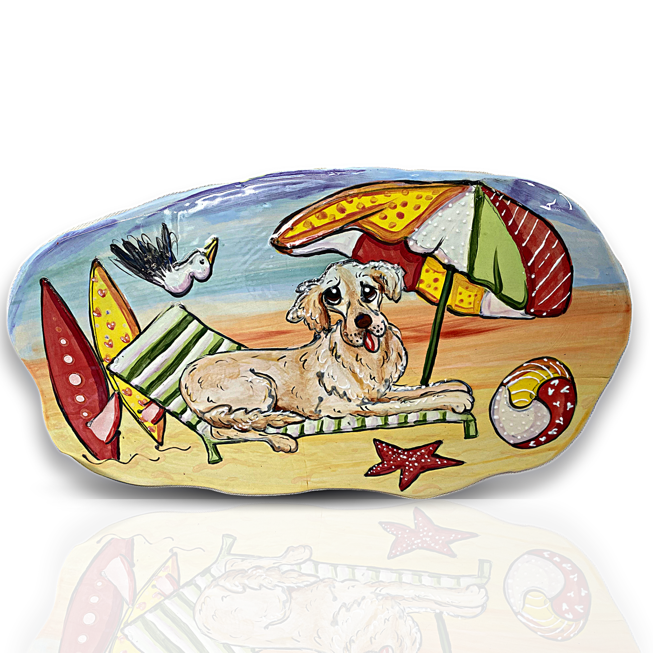 Handmade ceramic tile with a whimsical painting of a dog relaxing on a beach chair under an umbrella, with surfboards and a seagull flying by, created by artist Debby Carman