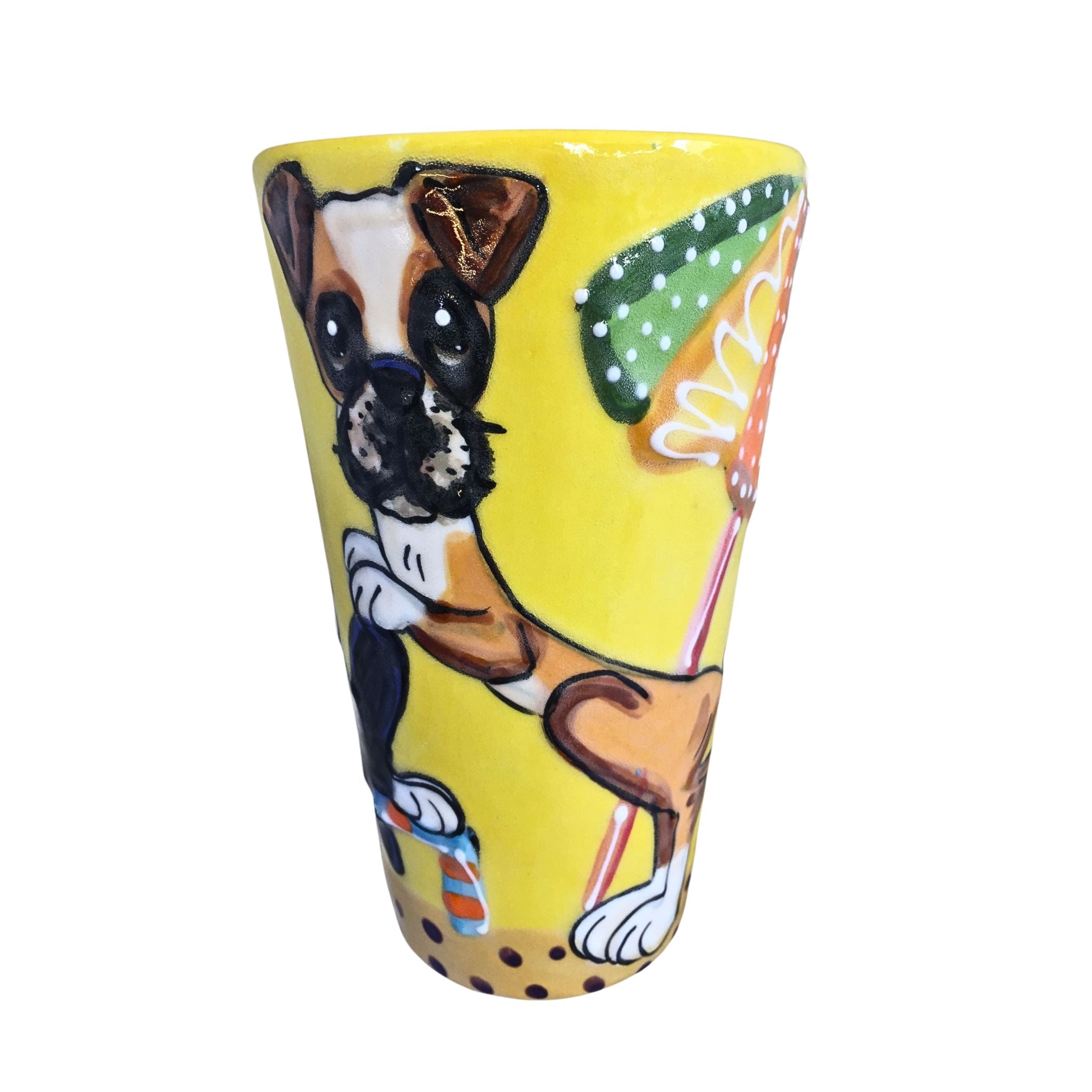 A 16 oz tall mug with a hand-painted Boxer dog in a playful stance against a bright yellow background with beach ball accents, created by Debby Carman.