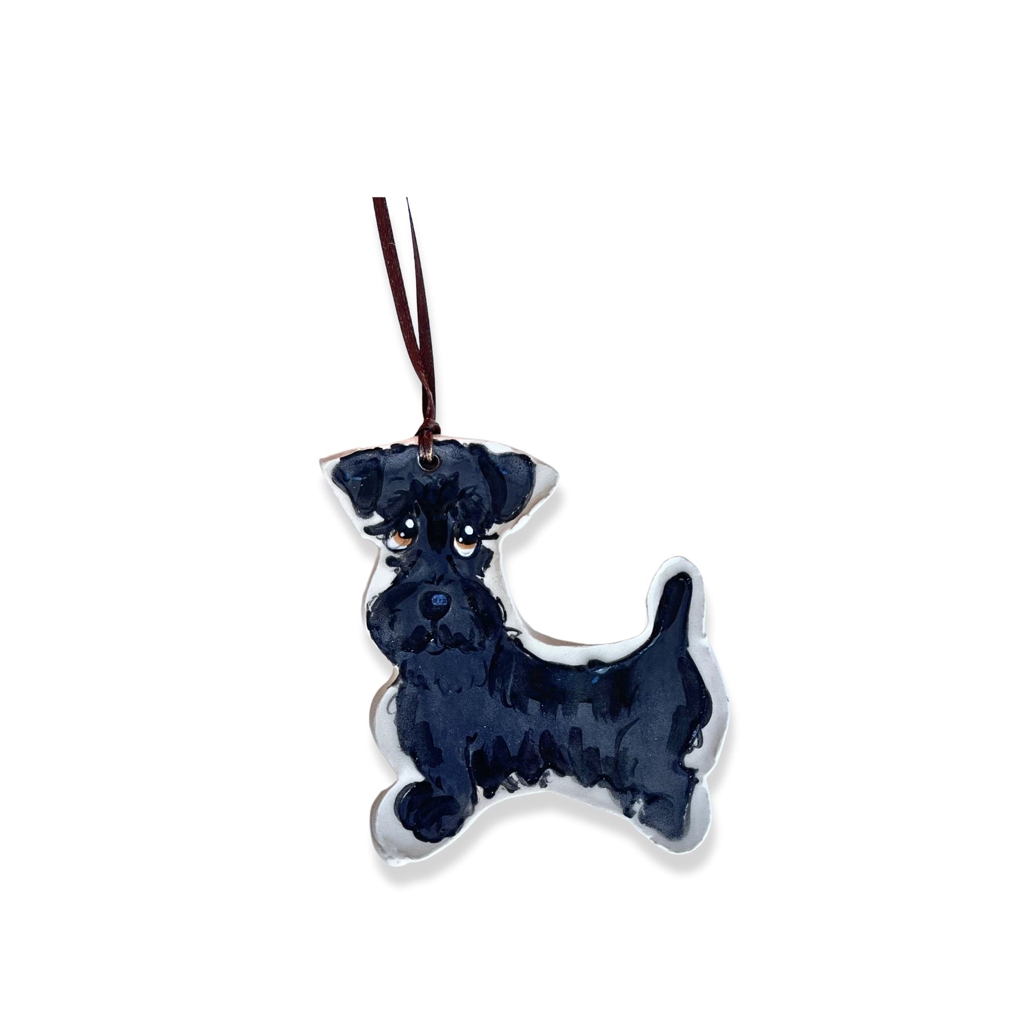 Ceramic ornament depicting a detailed black schnauzer puppy with an attentive expression, hung by a black ribbon