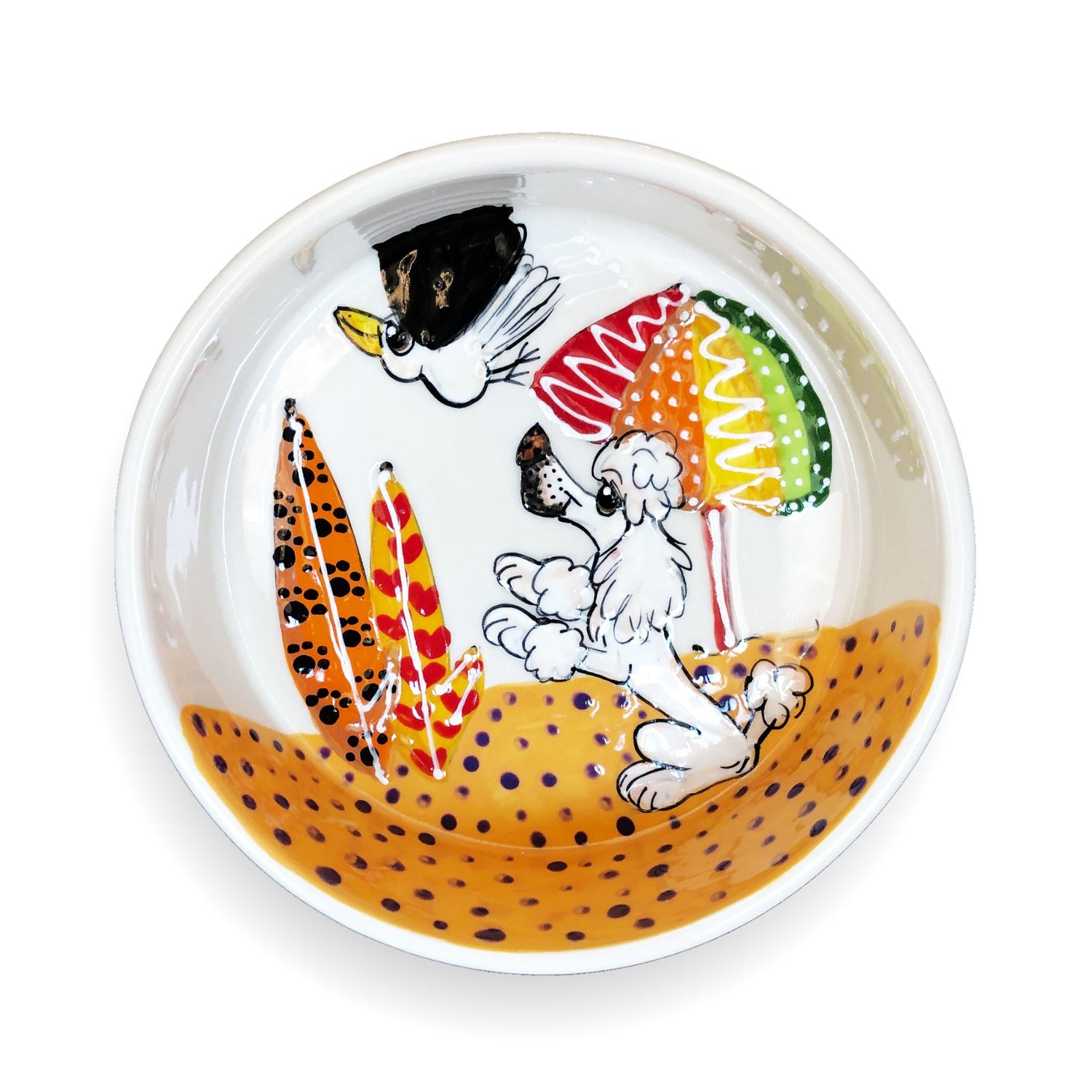 Artisanal ceramic pet bowl showcasing a white poodle and a black bird enjoying a sunny beach setting with colorful beach umbrellas, illustrated by Laguna Beach artist Debby Carman