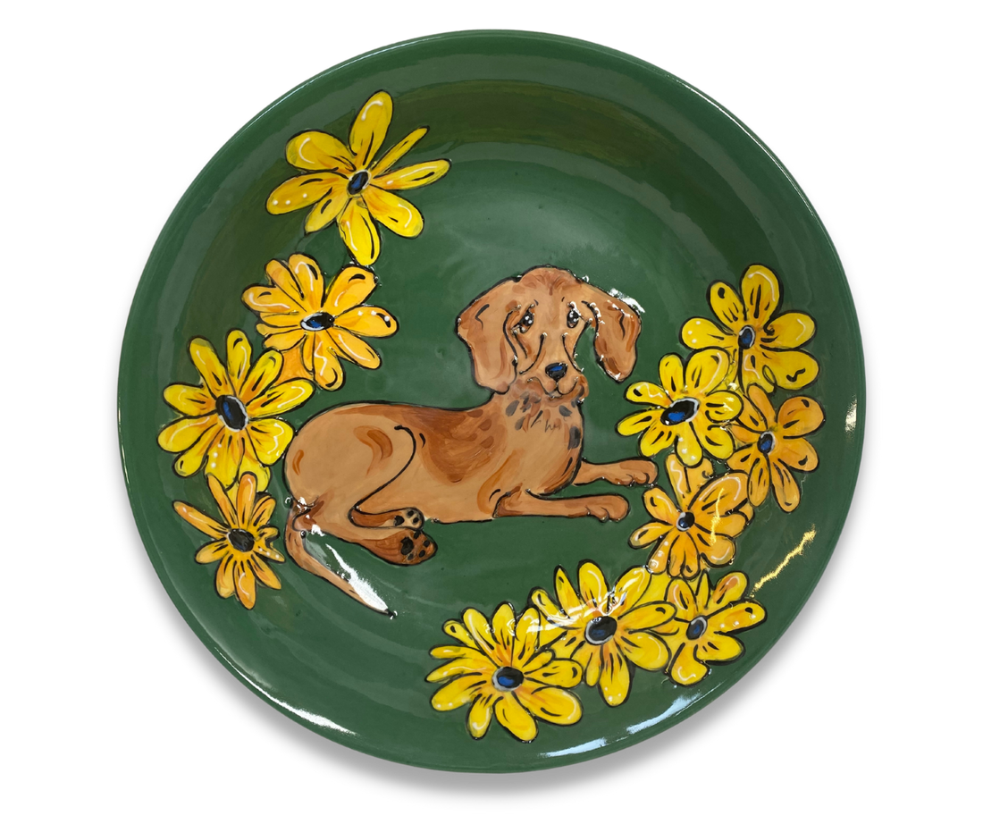 Handmade 14-inch ceramic serving bowl with a hand-painted whimsical depiction of an adorable Dachshund surrounded by yellow flowers, crafted by artist Debby Carman