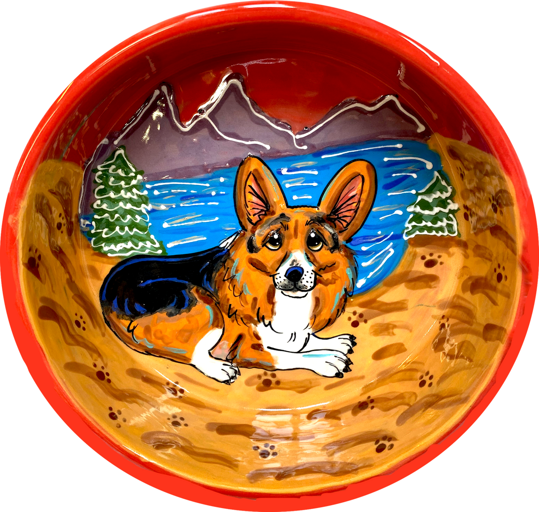 photo of glazed red ceramic bowl with corgi on personalized pet bowl with Lake Tahoe in the background, by Debby Carman, faux paw petique