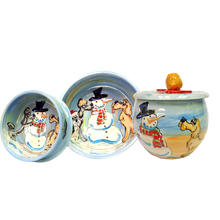 Set of ceramic bowls and a lidded jar featuring whimsical hand-painted scenes of snowmen with assorted playful dogs in a wintry backdrop